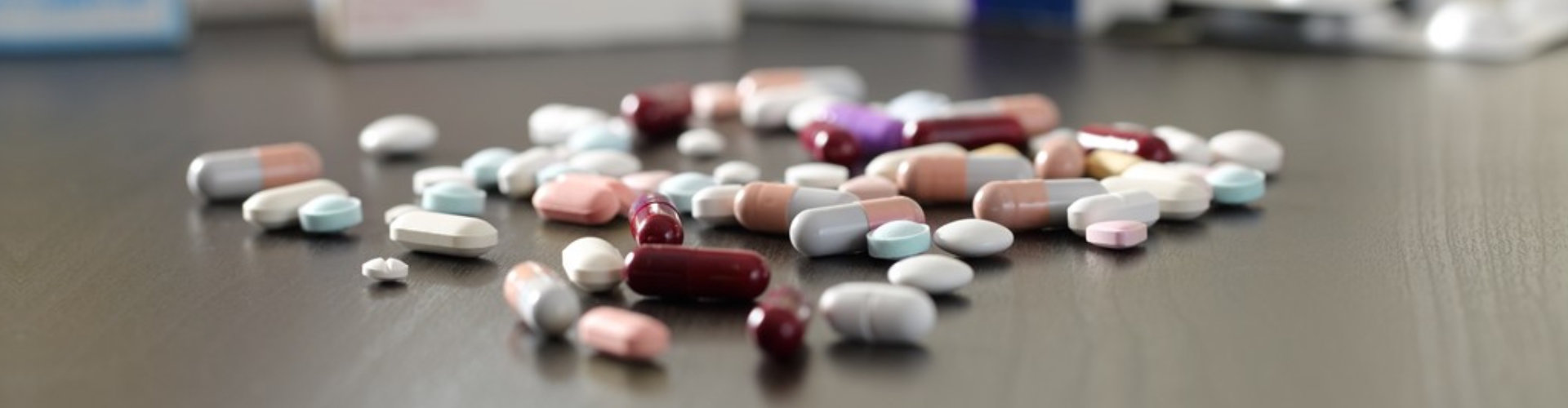 lot of pills and medicines on a black wooden table